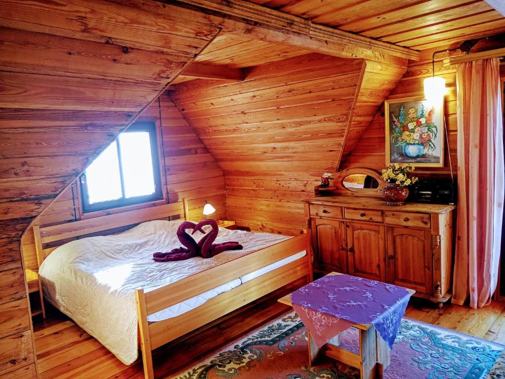 Un dormitorio con una cama con una cinta morada. en Sępia Chata Dom Do Wynajęcia, en Świeradów-Zdrój