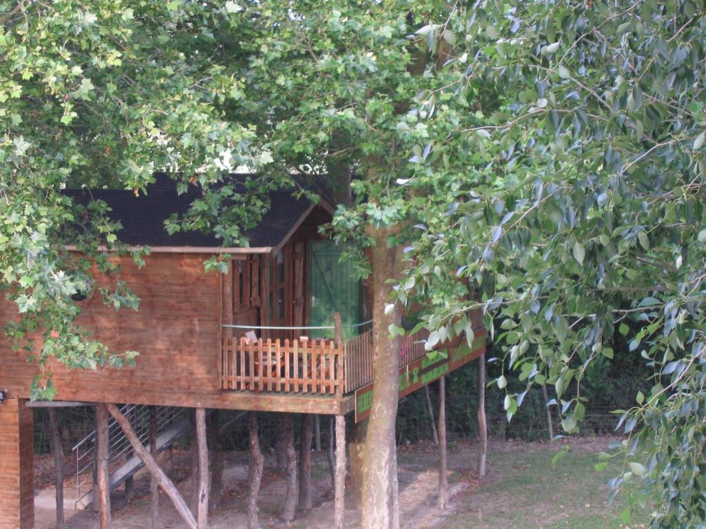 ein Baumhaus mit einer Terrasse in den Bäumen in der Unterkunft Camping belle rivière in Chaniers