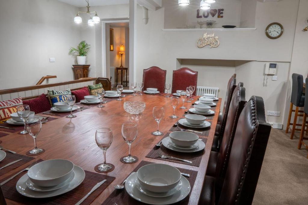 a long table with plates and wine glasses on it at Forrest's Yard - Apartment 1 in Kendal