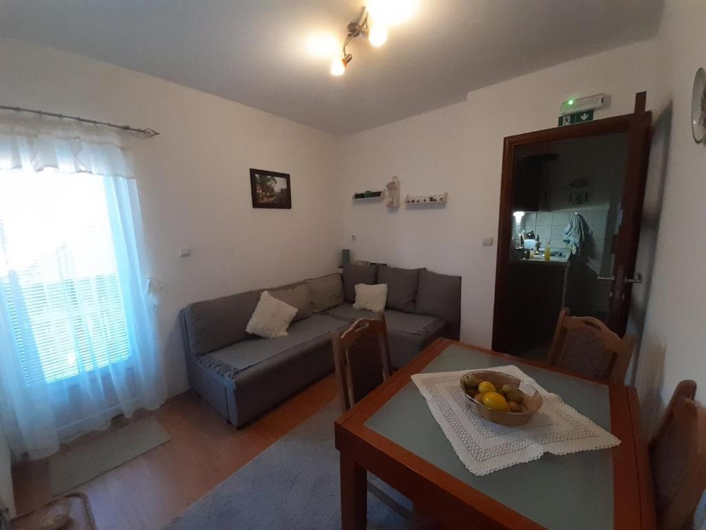 een woonkamer met een bank en een tafel bij Apartman Nik in Zlatibor