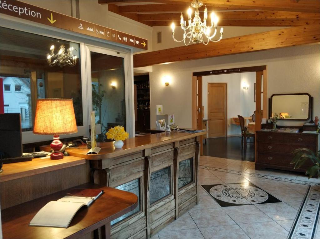 a large room with a desk with a lamp at Hotel Calisola in Chalezeule