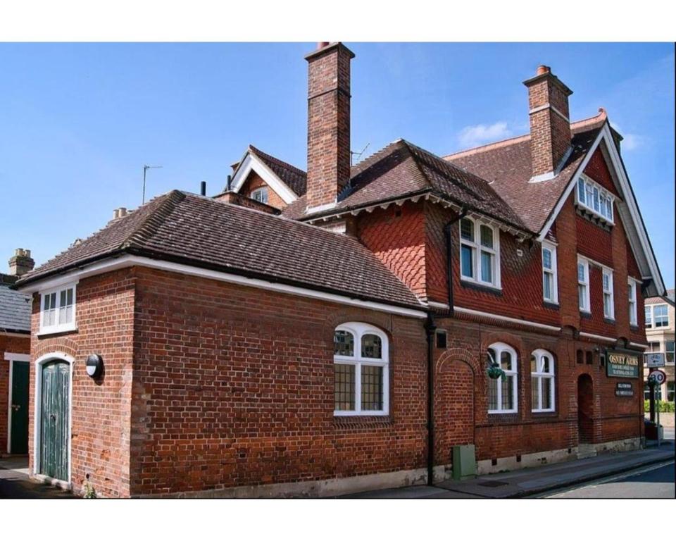 - un bâtiment en briques rouges avec une cheminée dans une rue dans l'établissement The Osney Arms Guest House, à Oxford