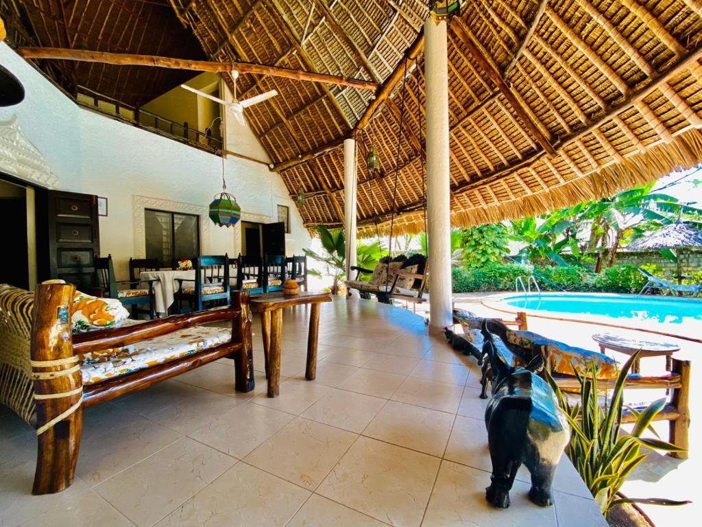 a dog standing in the middle of a room with a pool at Villa Madinina in Diani Beach