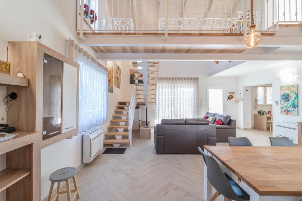 uma sala de estar e sala de jantar com um loft em Capriccio Mediterraneo em Sassari