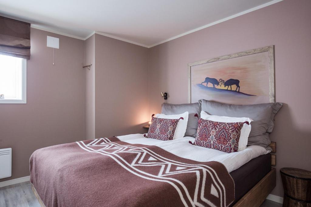 Schlafzimmer mit einem Bett mit Wandgemälde in der Unterkunft 8 SEASONS in Varangerbotn