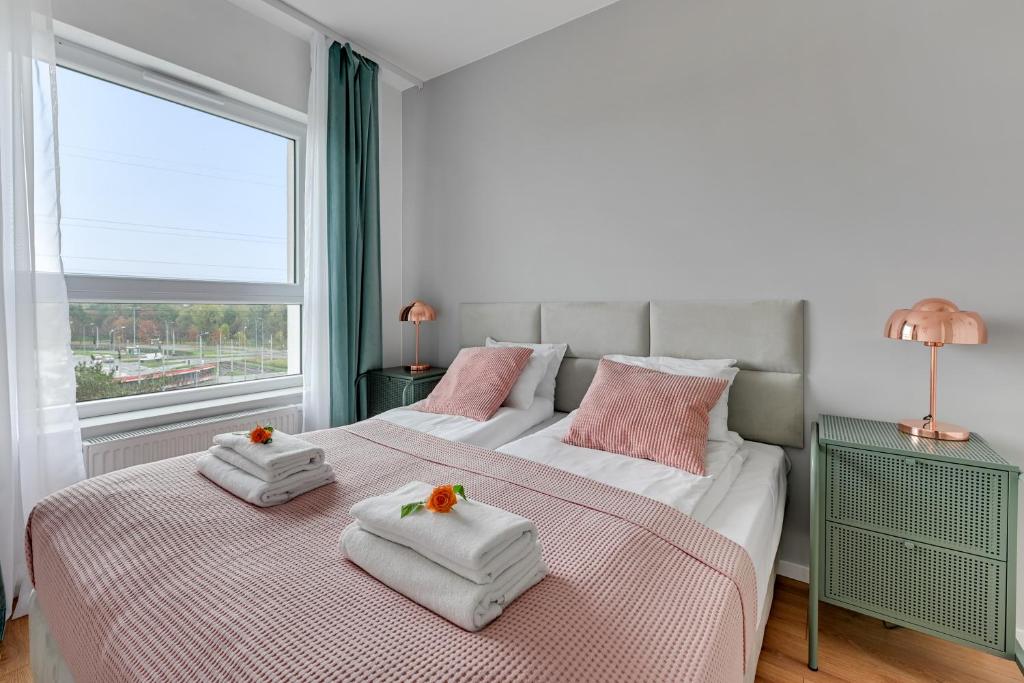 two beds in a room with two towels on them at Baltica Sky by TriApart in Gdańsk