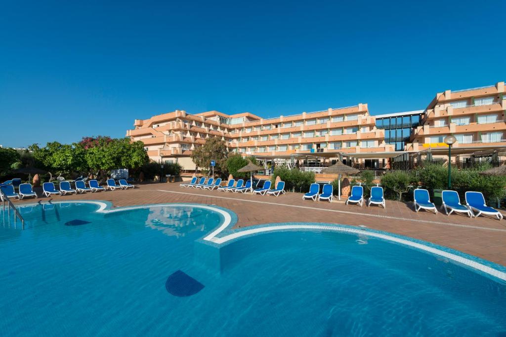 a large swimming pool with chairs and a hotel at Hotel Mariant Park in Sa Coma