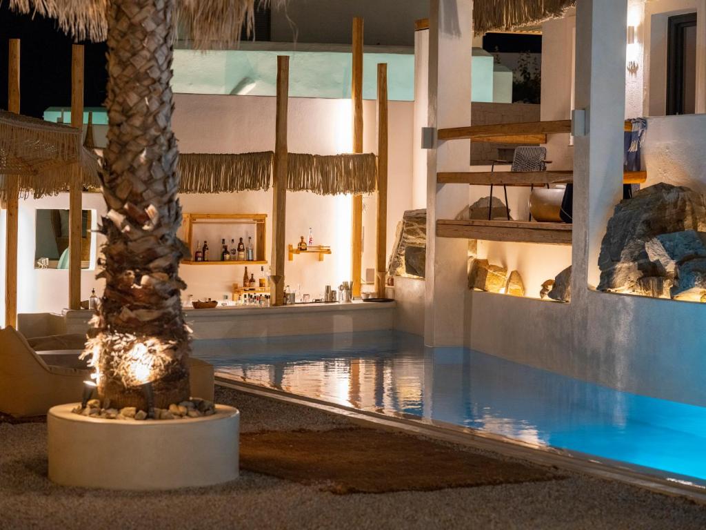 a hotel lobby with a palm tree and a swimming pool at Sandaya Luxury Suites in Naousa