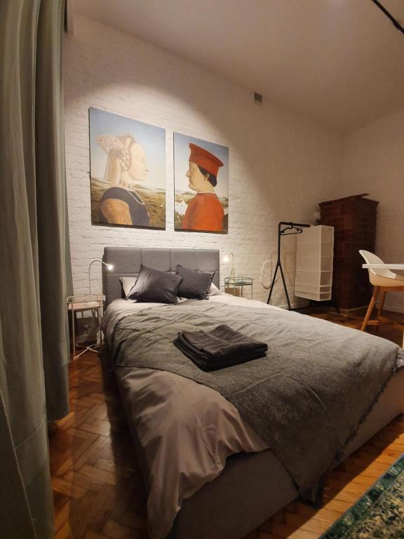 Un dormitorio con una cama con tres cuadros en la pared. en Takie studio, że żal nie wynająć, en Łódź