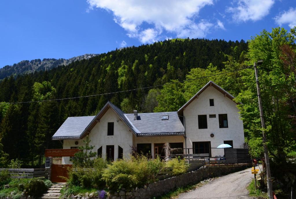 une maison blanche avec une montagne en arrière-plan dans l'établissement Les ateliers du Cucheron, à Saint-Pierre-de-Chartreuse