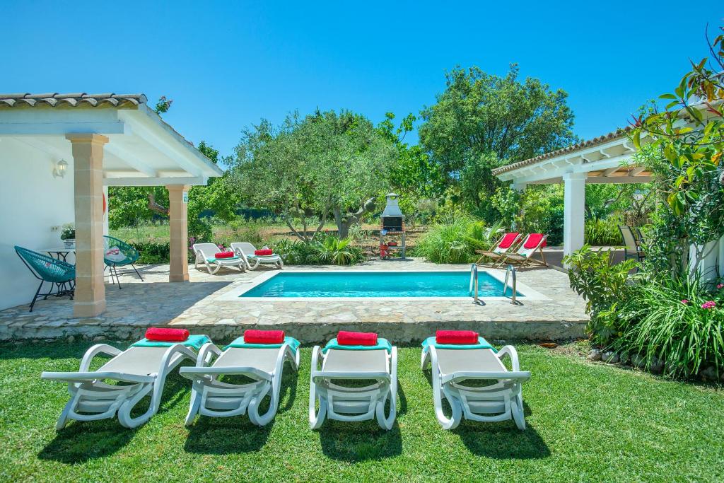 ポリェンサにあるOwl Booking Villa Guacamayo - Vacation Paradiseの芝生の椅子とスイミングプール