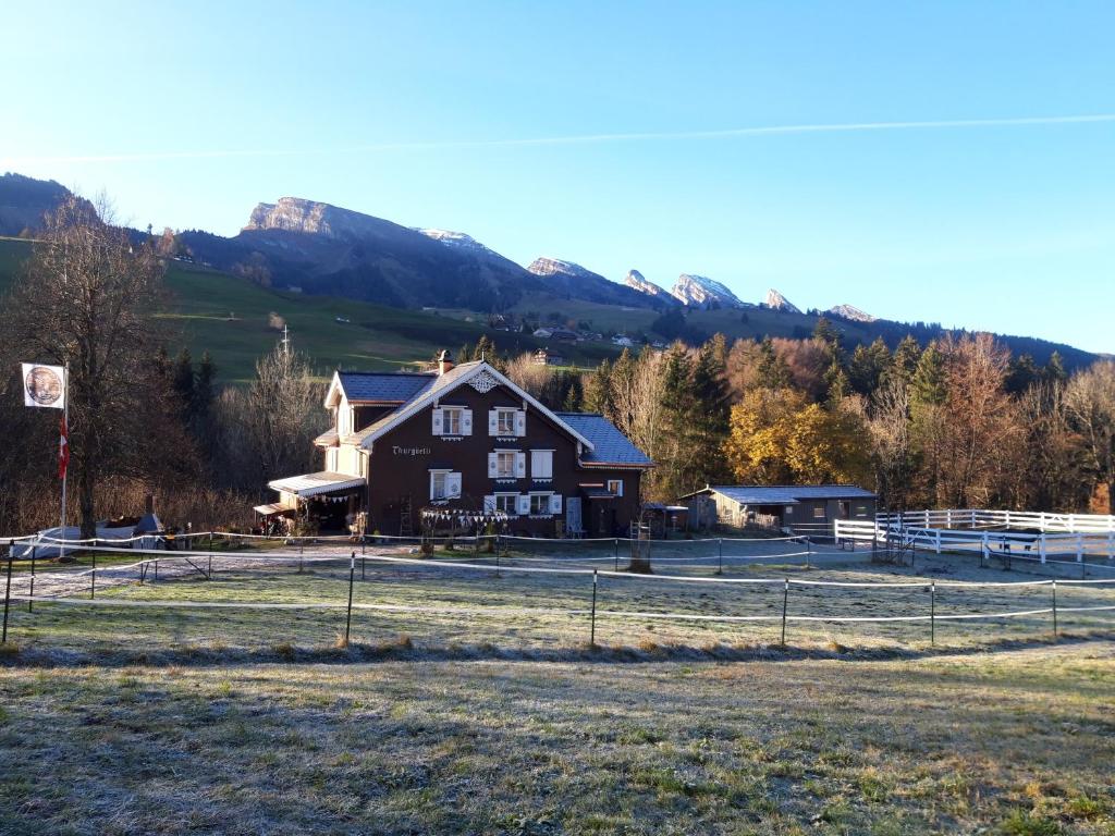 a large brown house with mountains in the background at Studio Chic mit Whirlpool in Wildhaus