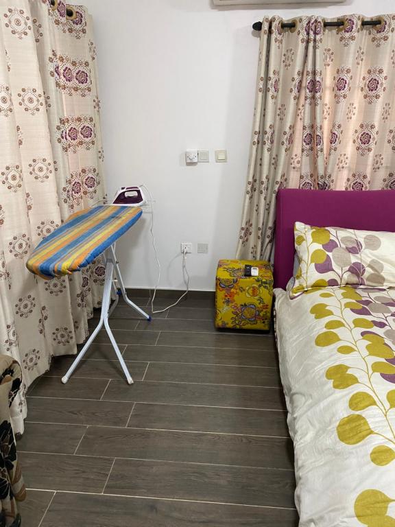 um quarto com uma cama, uma cadeira e cortinas em Cosy 3 bedroom holiday apartment for rent em Sakumona