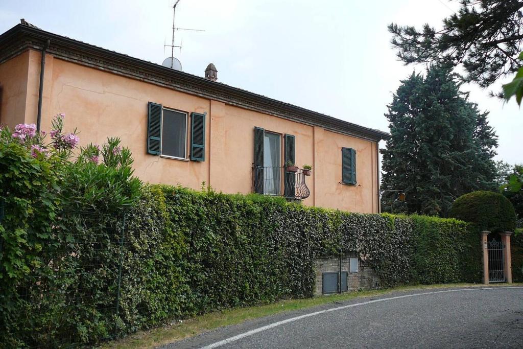 een huis met een heg voor een gebouw bij Charming 1-Bed Apartment in Castell'Arquato in CastellʼArquato