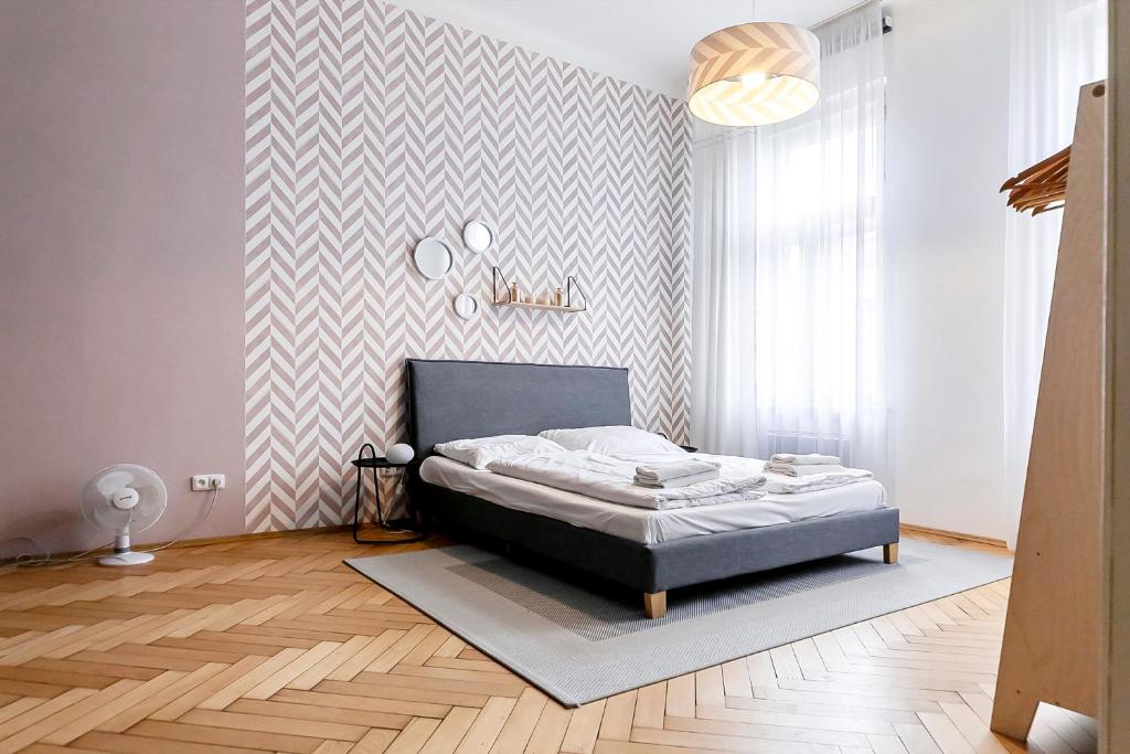 a bedroom with a bed and a geometric wall at Modern apartment 10 minutes from Old Town! in Prague