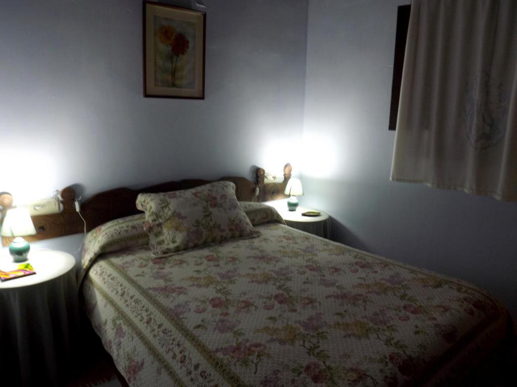 CepedaにあるCasa Melaniaのベッドルーム1室(ベッド1台、テーブル2台、ランプ2つ付)