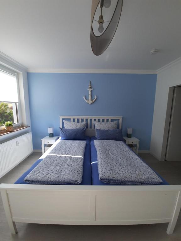 a blue bedroom with a large bed with blue walls at Ferienwohnung Seestern 61 in Bremerhaven