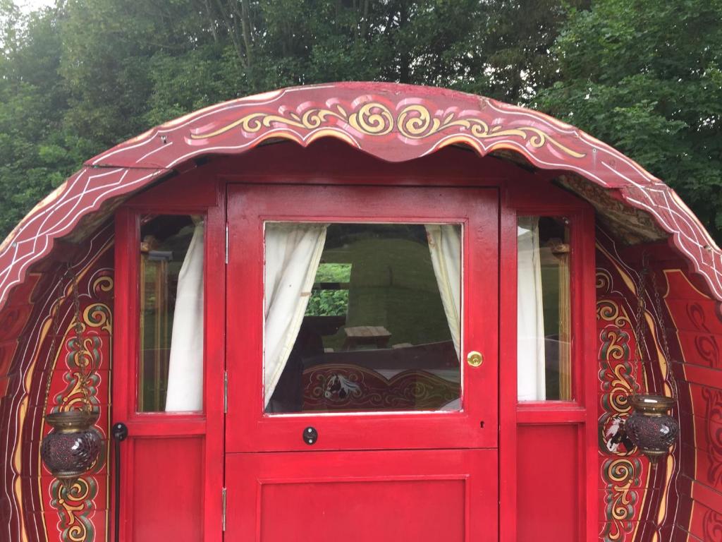 una puerta roja con una ventana encima en Islay Westcote Glamping en Hawick