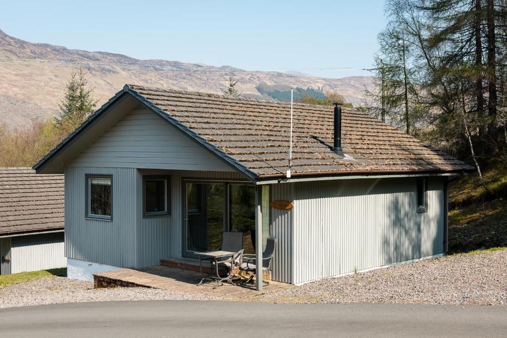 a small house on a gravel road with a dstg at Deerstalker chalet in Crianlarich
