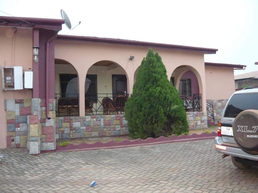 a car parked in a parking lot in front of a building at A Spacious 3 Bedroom House in Kumasi