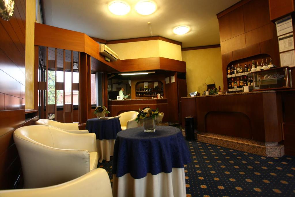 a restaurant with a table and chairs and a bar at Hotel Lincoln in Cinisello Balsamo