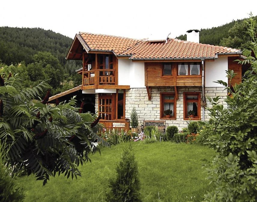 ein Haus mit grünem Rasen davor in der Unterkunft Zhivka House in Glavatartsi