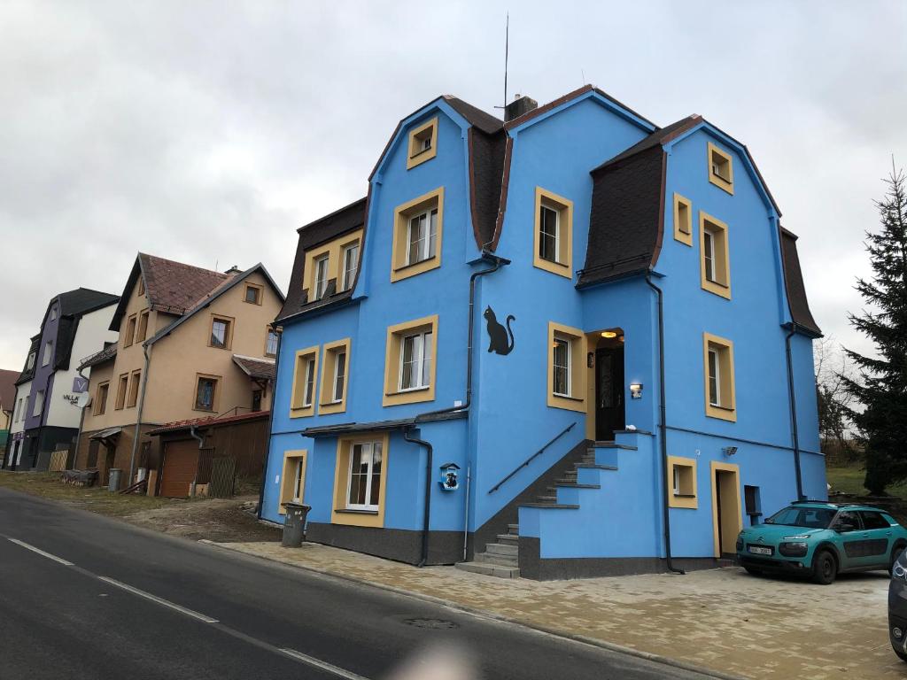 a blue house on the side of a street at Apartmány U Kocoura pod Klínovcem in Kovářská