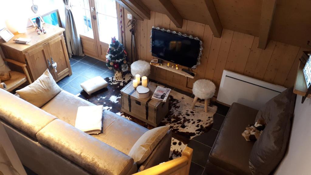 einen Blick über ein Wohnzimmer mit Sofa in der Unterkunft Duplex 6-8 pers, avec garage, WIFI, calme, proche des pistes, top équipé et linges fournis, vue magnifique in Saint-Gervais-les-Bains