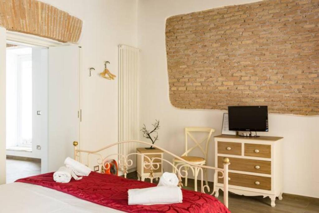 a bedroom with a red bed and a tv at Pellegrino 75 Actual in Rome