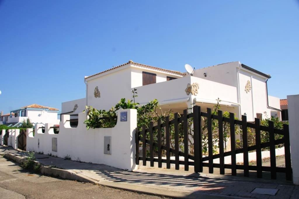 a white house with a fence in front of it at 2 bedrooms house at Calasetta 400 m away from the beach with enclosed garden in Calasetta