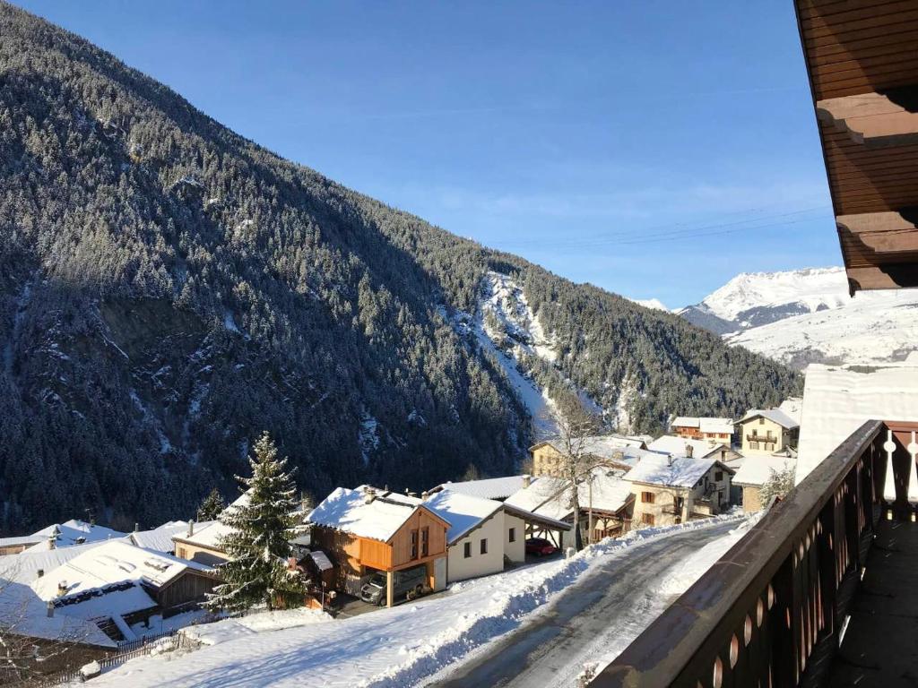 a snow covered village with a mountain in the background at Chalet de 3 chambres a Peisey Nancroix a 500 m des pistes avec terrasse et wifi in Peisey-Nancroix