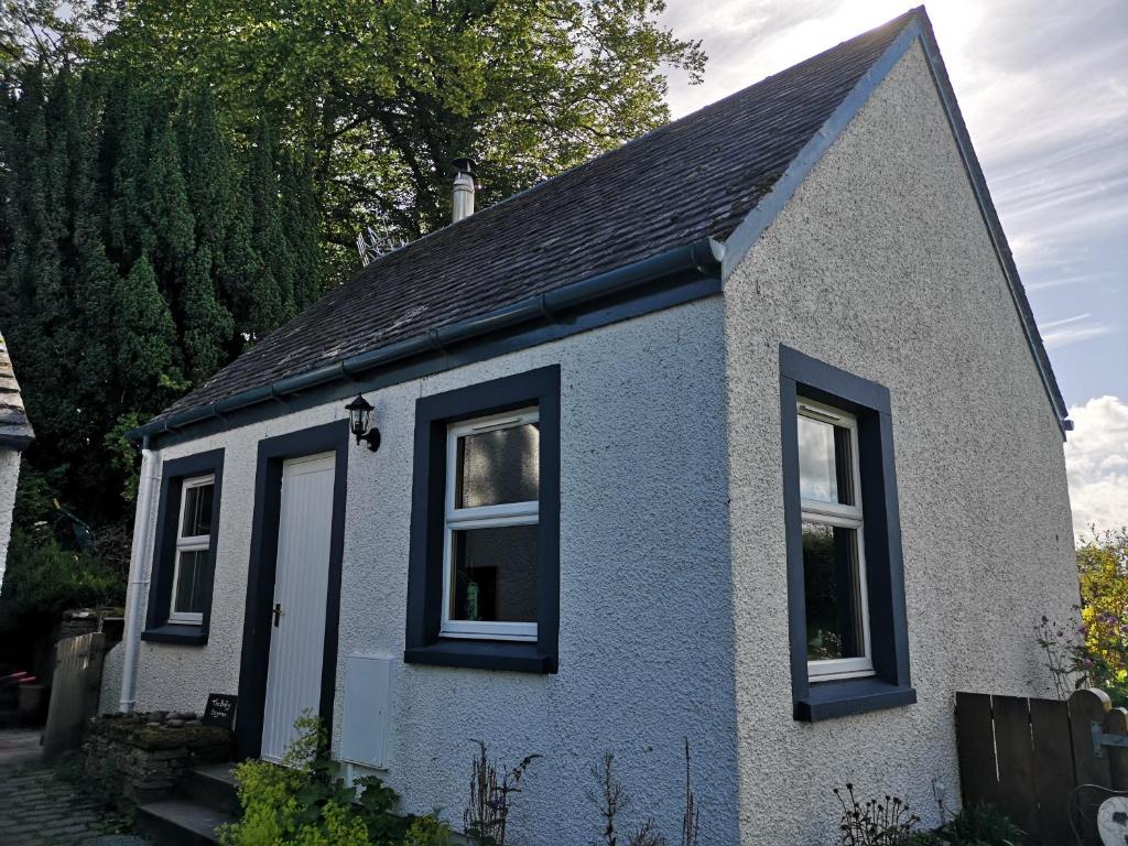 a small house with two windows and a roof at Private Cottage Bothy near Loch Lomond & Stirling in Buchlyvie