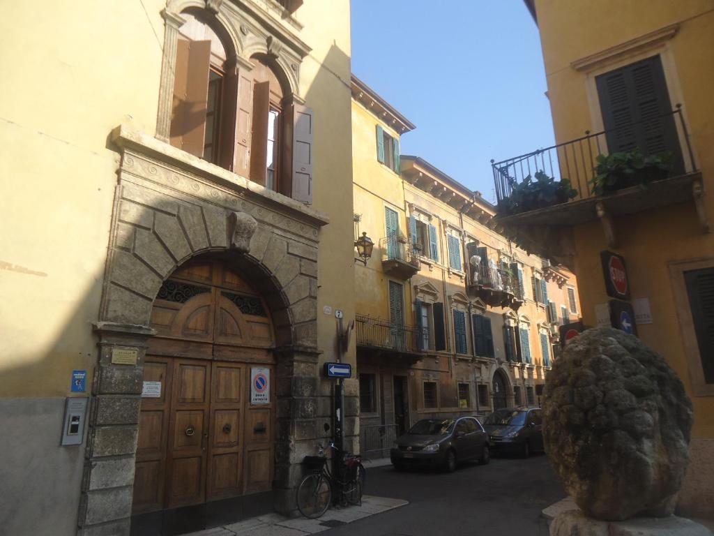 a building with a large wooden door on a street at Protezione della Giovane - female hostel in Verona