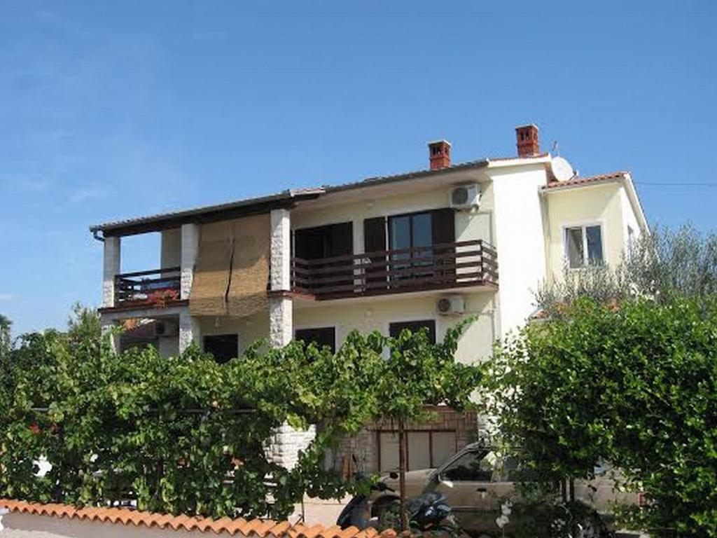 uma grande casa branca com árvores em frente em Apartments Branka em Medulin