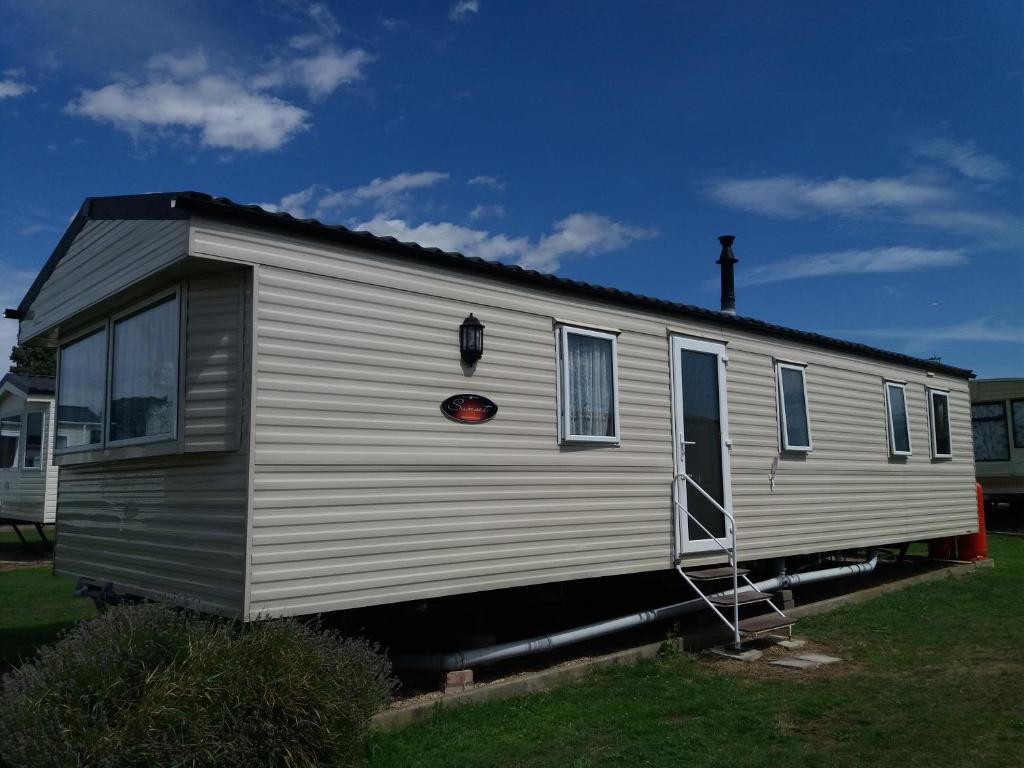 a mobile home with a ladder on the side of it at 2013 Willerby Sunset Static Caravan Holiday Home in Clacton-on-Sea