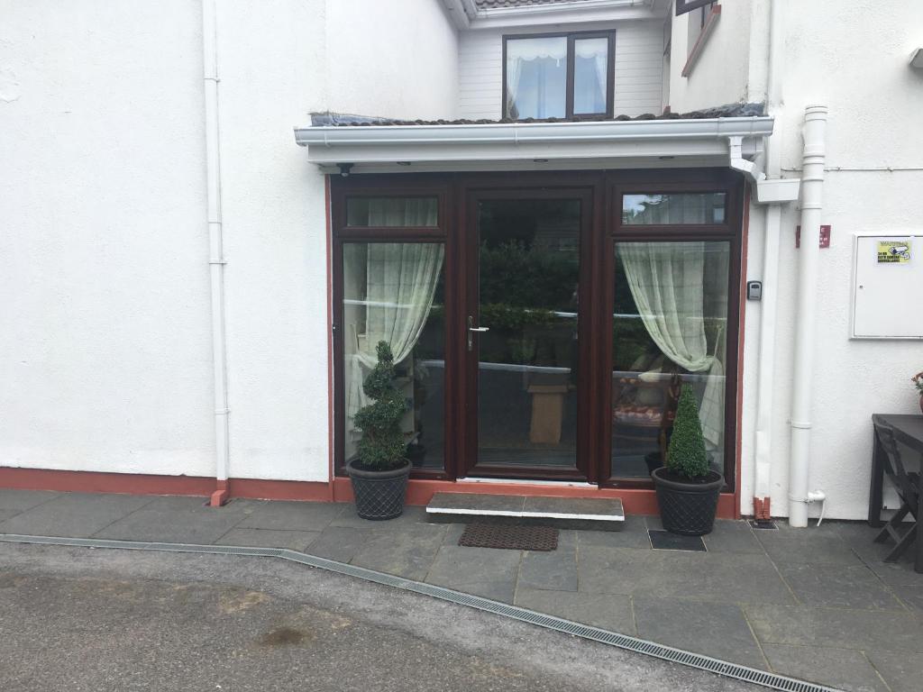 a front door of a house with two potted plants at Hazelbrook Self Catering - Maximum 6 persons in Westport