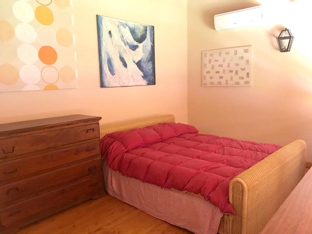 - une chambre avec un lit rouge et une commode dans l'établissement Studio with shared pool and wifi at Grammichele, à Grammichele