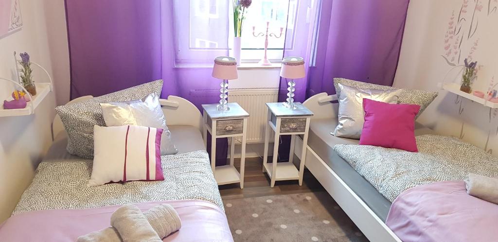a purple room with two beds and two tables at ELENA flat Lavendel Duisburg Zentrum in Duisburg