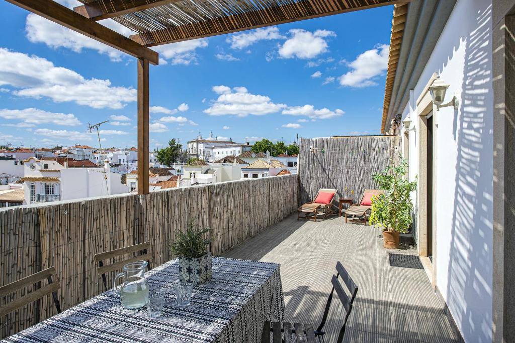 a patio with a table and chairs on a balcony at Comfortable Apartment Tavira + Terrace in Tavira