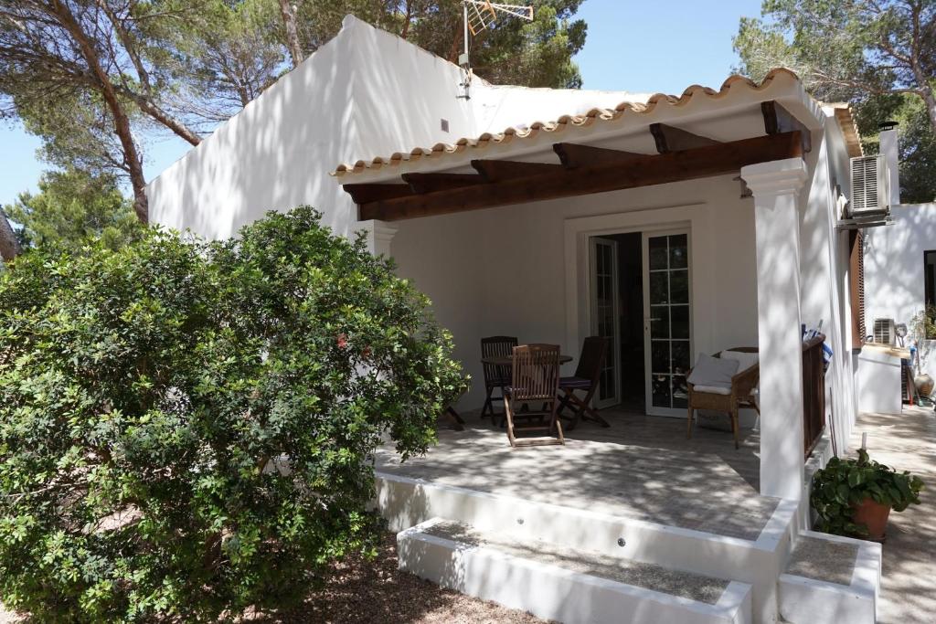 プラヤ・ミジョーンにある2 bedrooms house at Platja de Migjorn 600 m away from the beach with furnished garden and wifiの白い家(ポーチ付)