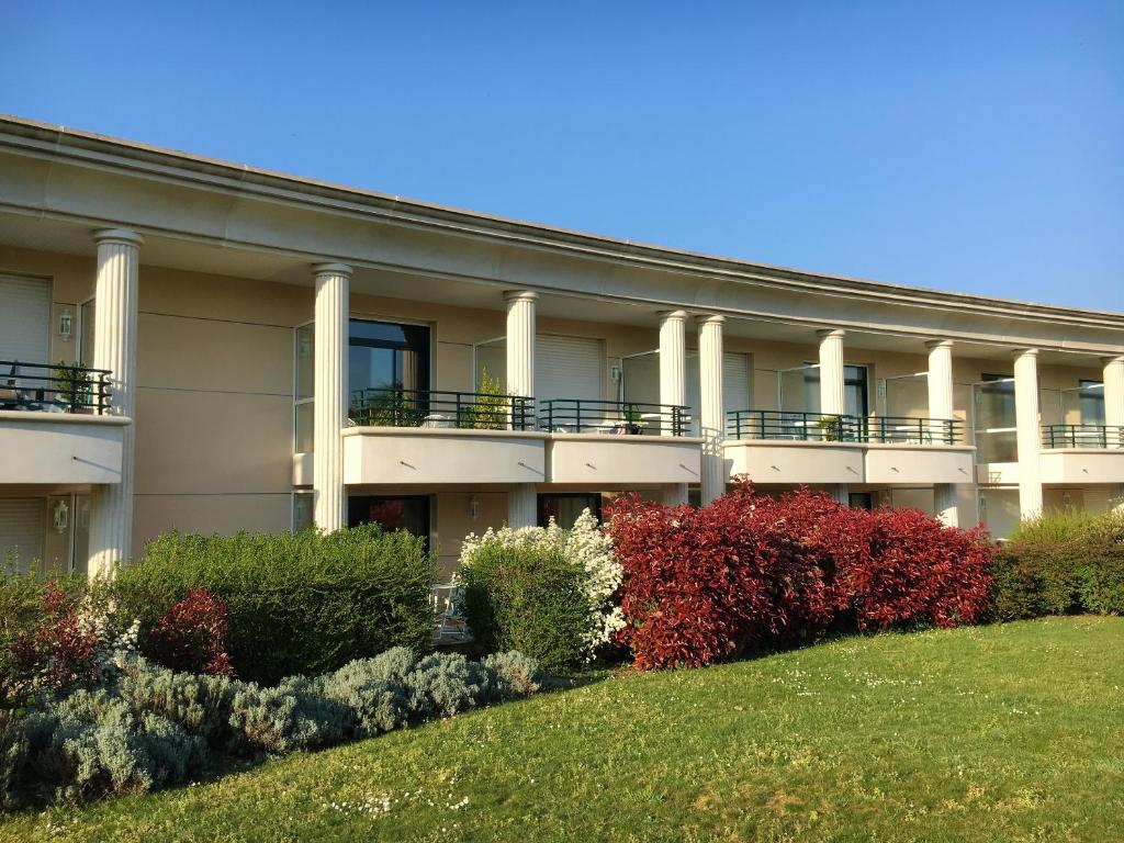 Un edificio de apartamentos con césped delante. en Appartement cosy à Saint-André-des-Eaux de 47 m² avec jardin, en Saint-André-des-Eaux