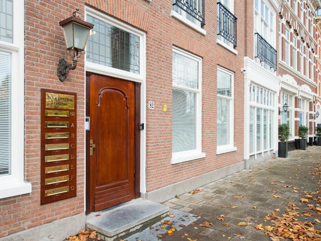 a brick building with a wooden door on a street at Bizstay Park Central Executive in The Hague