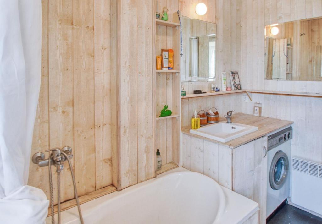 a bathroom with a tub and a sink and a washing machine at Maison de 3 chambres avec vue sur la mer jardin clos et wifi a Regneville sur Mer a 2 km de la plage in Regnéville-sur-Mer