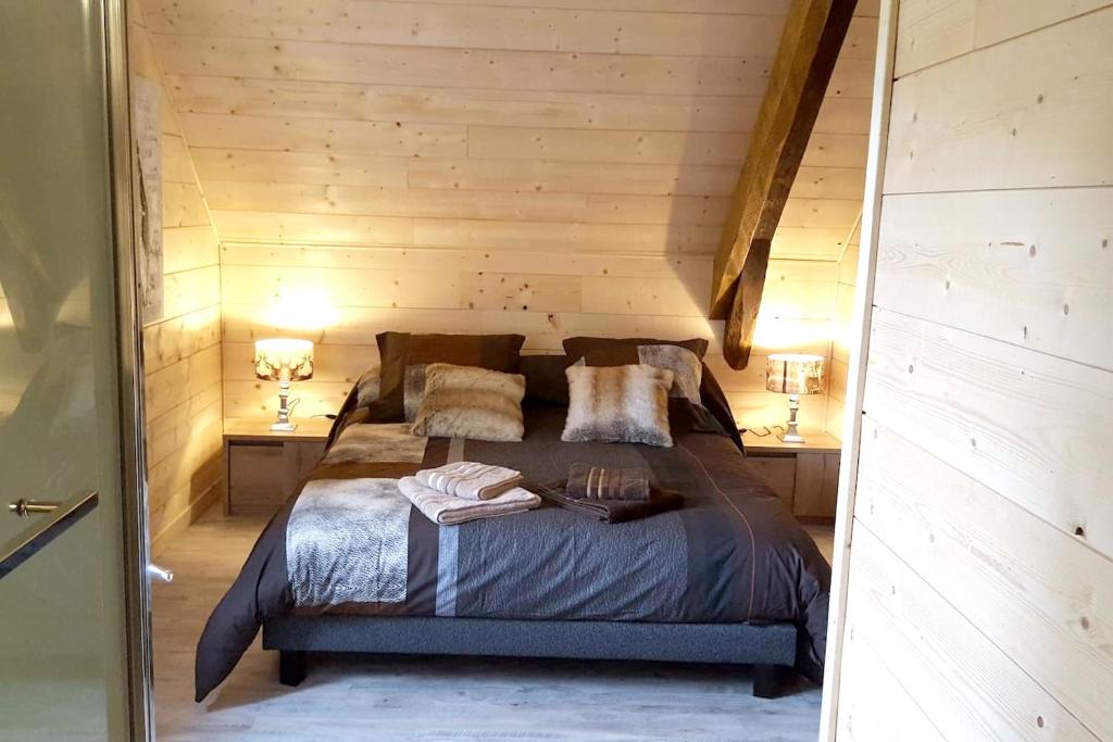 a bedroom with a bed in a wooden wall at Villa spacieuse avec piscine à Aspin-en-Lavedan, vue montagne. in Aspin-en-Lavedan