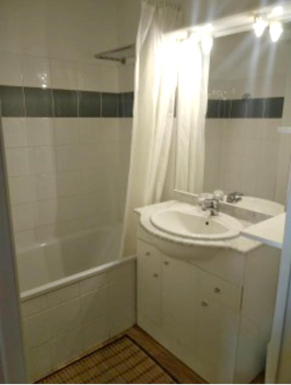 a white bathroom with a sink and a tub and a shower at Appartement de 2 chambres avec vue sur la ville piscine partagee et terrasse a La foux d&#39;Allos in La Foux