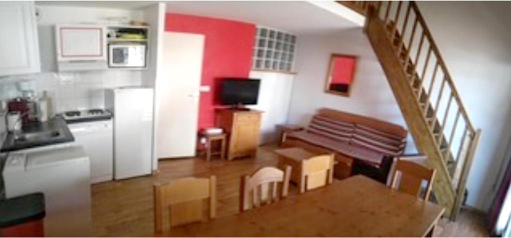 a living room with a kitchen and a stairway at Appartement de 2 chambres avec vue sur la ville piscine partagee et terrasse a La foux d&#39;Allos in La Foux