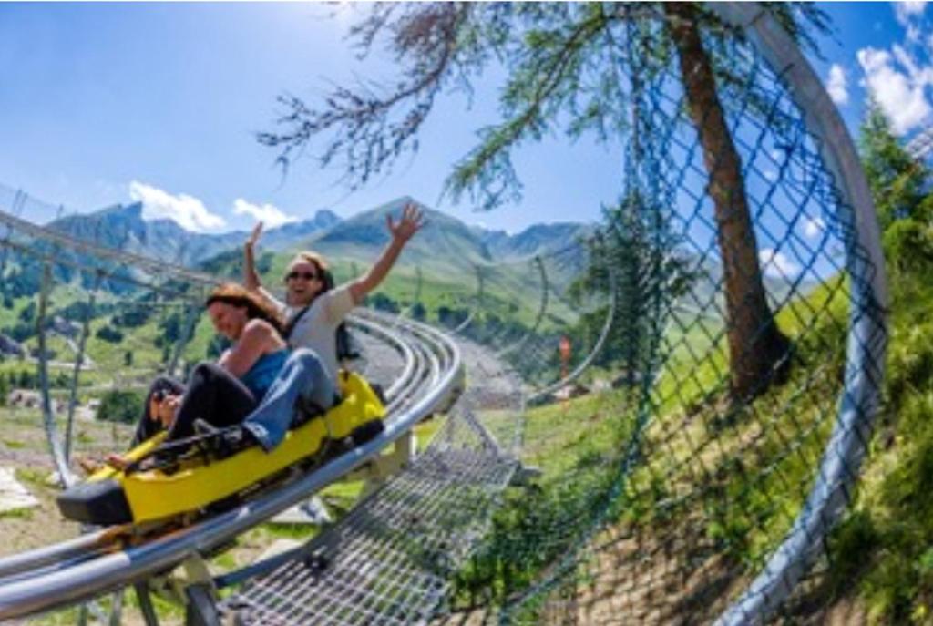 two people are riding on a roller coaster at Appartement de 2 chambres avec vue sur la ville piscine partagee et terrasse a La foux d&#39;Allos in La Foux