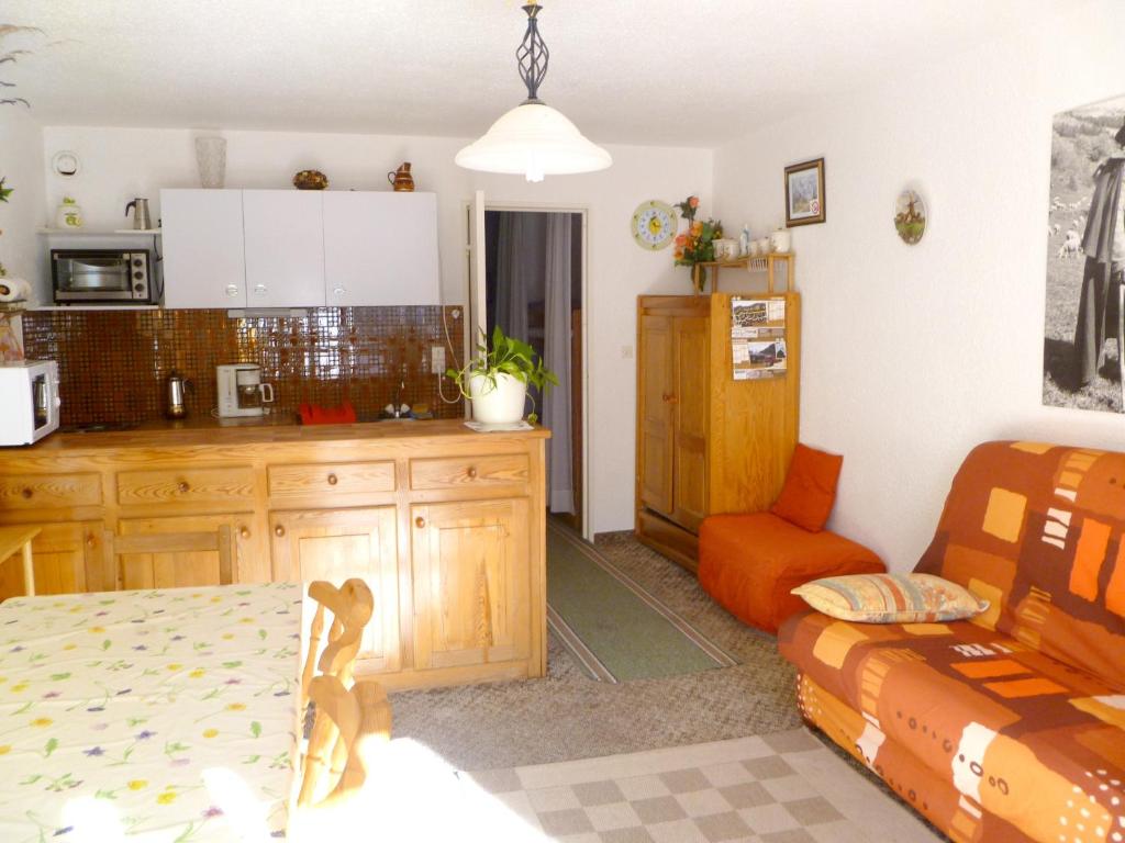 a kitchen and living room with a couch and a table at Appartement d'une chambre avec balcon a Enchastrayes in Enchastrayes