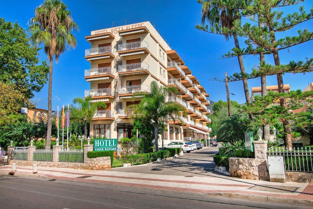 a large apartment building on a street with palm trees at Vista Alegre in Benicàssim