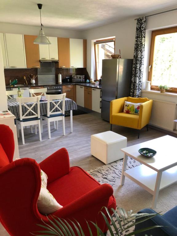 Il comprend un salon avec des chaises rouges et une cuisine. dans l'établissement Apartment Ida, à Innsbruck